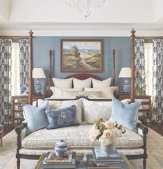 a bedroom with blue walls and white furniture