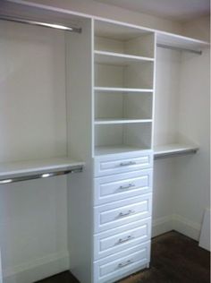 an empty white closet with drawers and shelves