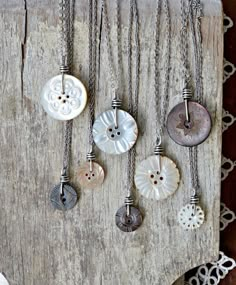 several different types of buttons are hanging on a piece of wood