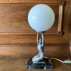 a lamp that is sitting on top of a wooden table in front of a wood paneled wall