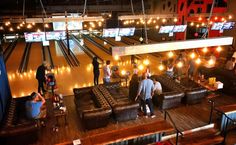 bowling alley with people sitting on couches and bowling pins