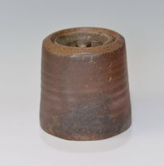 a small brown vase sitting on top of a white table