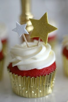 cupcakes with white frosting and gold stars on top