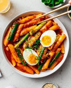 a bowl filled with carrots, asparagus and hard boiled egg on top