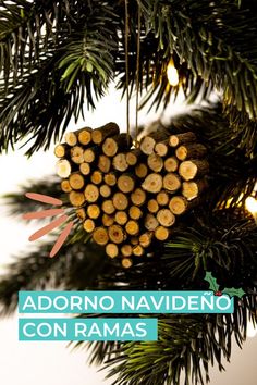 a heart shaped ornament hanging from a christmas tree with the words adorno naviddeno con ramas