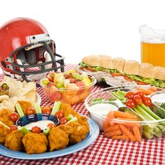 a table topped with plates of food and a football helmet