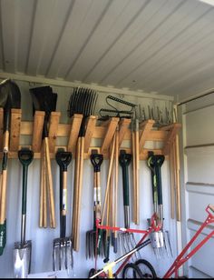 there are many gardening tools hanging on the wall