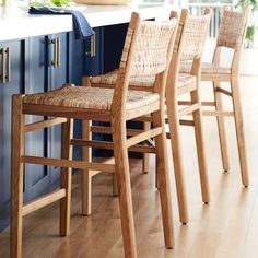 a kitchen with blue cabinets and wooden chairs