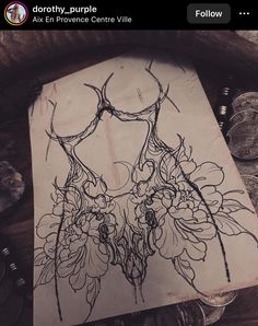 a drawing on paper with flowers in the middle and an image of a woman's torso