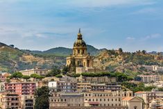 the city is surrounded by mountains and hills, with buildings on each side in front of it