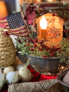 a candle is lit next to some eggs and other decorations on a table with an american flag in the background