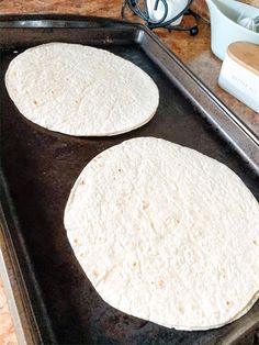 two tortillas sitting on top of a metal pan