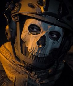 a man wearing a skull mask and helmet with his eyes wide open in the dark