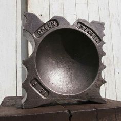 a metal object sitting on top of a piece of wood next to a white wall