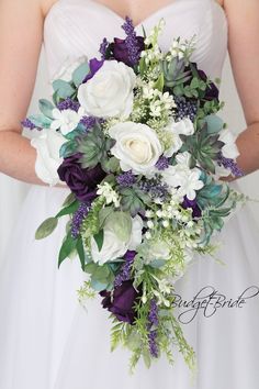 a bride holding a bouquet of white and purple flowers