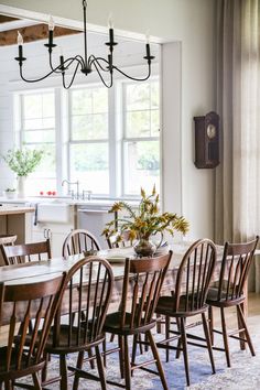 a dining room table with chairs and a potted plant on top of the table