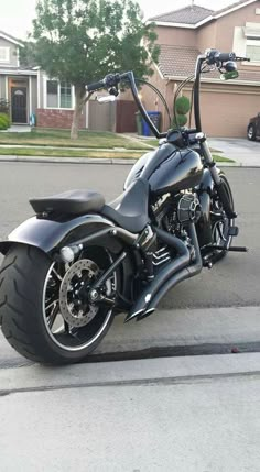 a black motorcycle parked on the street in front of some houses with no one around