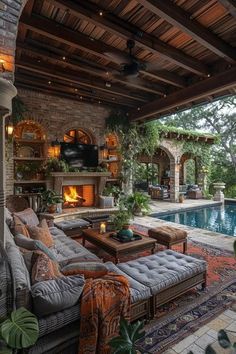 an outdoor living area with couches, tables and a pool in the back ground