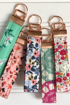 four keychains with flowers on them hanging from hooks