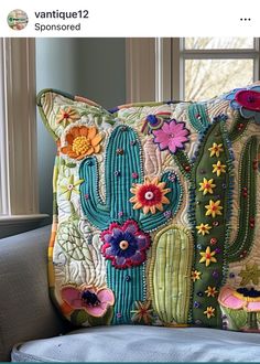 a cactus pillow on a couch in front of a window with the caption, i'm not sure what this is