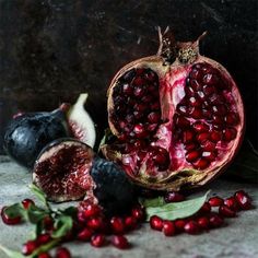 the pomegranate has been cut open and is next to some other fruits