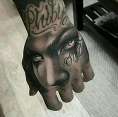 a person with tattoos on their hand and face