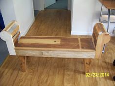 a wooden bench sitting on top of a hard wood floor