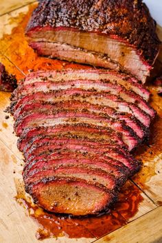 sliced up meat sitting on top of a wooden cutting board