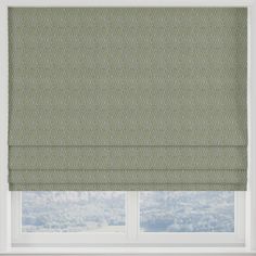 a green roman blind in front of a window with the blinds pulled back to reveal an abstract pattern