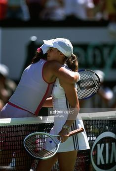 two female tennis players hugging each other on the court