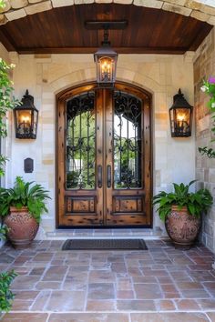 two large planters are on the outside of a house with an entry door and sidelights