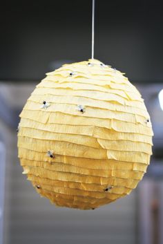 a yellow paper ball hanging from a ceiling