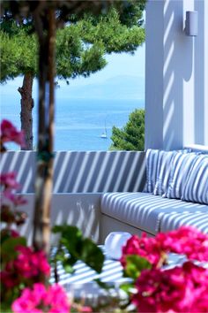 a couch sitting on top of a patio next to flowers