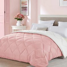 a bedroom with pink walls, white bedding and light green comforter on the bed