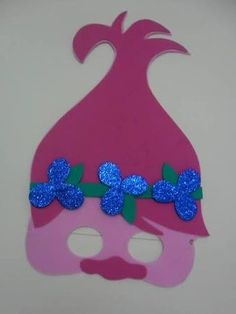 a pink mask with blue flowers on the top and green leaves on the bottom, against a white background