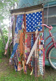 a bike parked next to a blue bus covered in ties