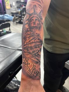 a man's arm with a statue of liberty tattoo on it