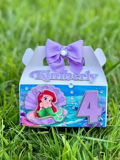 the little mermaid birthday box is sitting in the grass with its number four on it