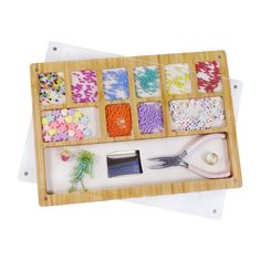 a wooden tray with buttons, beads and scissors