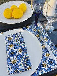 a table set with plates, glasses and lemons