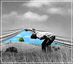 a man bending over in the middle of a field with trees and clouds behind him