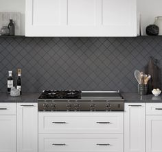 a stove top oven sitting inside of a kitchen next to white cupboards and counter tops