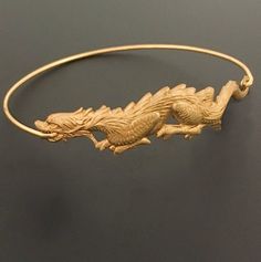 Dragon Bangle Bracelet. A gold tone dragon charm will be transformed into a dragon bangle bracelet with bangle band choice of brass or 14k gold filled. Personalize your dragon bracelet with custom initial charms or birthstone charms to create a customized dragon charm bracelet;http://www.etsy.com/shop/FrostedWillow?section_id=6596366Please specify size in notes to seller during checkout for your dragon bangle bracelet. Choose from one of my regular sizes below or by measuring one of your favorit Chinese Dragon Jewelry, Adjustable Gold Charm Bracelet Collectible, Adjustable Gold Charm Bracelet, Chinese Jewelry Traditional, Mystical Dragon, October Jewelry, Chinese Bracelet, Chinese New Year Gift, Dragon Chino