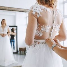 a woman in a wedding dress getting ready