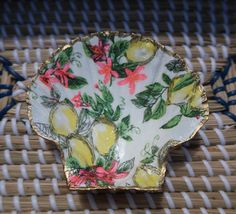 a yellow and pink flowered plate sitting on top of a wicker tablecloth