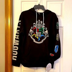 a black hoodie hanging on a door with patches and stickers all over it