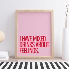 a pink poster with the words i have mixed drinks about feelings on it next to a white vase