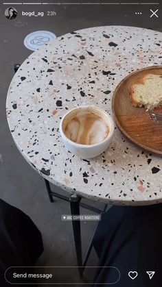 a cup of coffee sitting on top of a table next to a piece of cake