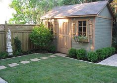 a small backyard with a shed and lawn