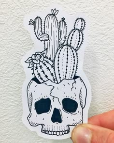 a sticker with a skull and cacti on it, in front of a white wall